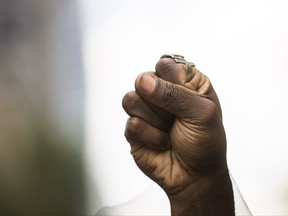 An activist from the Black Lives Matters movement holds up their hand during the Pride parade in Toronto, Sunday, June 25, 2017. (THE CANADIAN PRESS/Mark Blinch)