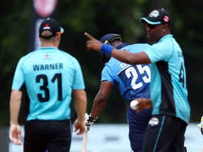 Dwayne Bravo of the Winnipeg Hawks (right) instructs teammate David Warner during a Global T20 Canada match at Maple Leaf Cricket Club on July 2, 2018 in King City, Ont.  (VAUGHN RIDLEY/Getty Images)