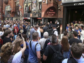 People queue outside the Cavern Club in Liverpool, England, before an exclusive gig by former Beatles member Paul McCartney, Thursday July 26, 2018. The former Beatle will take to the stage at the famous venue on Mathew Street for a one-off exclusive gig.