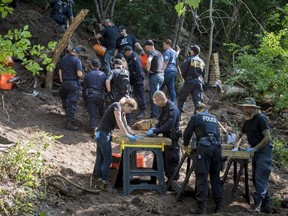 Members of the Toronto Police Service sift and excavate materials from the back of property along Mallory Cres. in Toronto after confirming they have found human remains during an investigation in relation to alleged serial killer Bruce McArthur on Thursday, July 5, 2018. THE CANADIAN PRESS/Tijana Martin