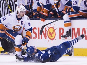 Former Islanders centre John Tavares trips up the Maple Leafs' Zach Hyman  during a game. The two could be linemates this season. (Nathan Denette/The Canadian Press)