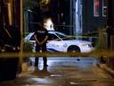 A Toronto Police Officer stands watch at an alley off  Danforth Ave. after a mass shooting in Toronto, Ontario, Canada on July 22, 2018. (Cole Burston/AFP/Getty Images)