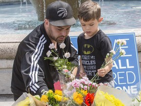 Police officer Norm Leung brought his four-year-old son Kai to pay their respects to the victims of the Danforth Ave. shooting on Tuesday, July 24, 2018. (Craig Robertson/Toronto Sun)