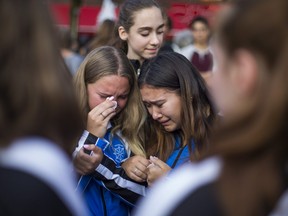 Members of the Markham Synchro club - shooting victim Julianna Kozis, 10, was a member - paying their respects during a vigil Alexander the Great Parkette along the Danforth at Logan Ave. in Toronto, Ont. on Wednesday July 25, 2018. (Ernest Doroszuk/Toronto Sun)