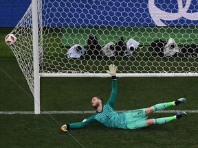 Spain's goalkeeper David De Gea dives and takes a goal kicked by Russia's forward Fedor Smolov in a penalty shootout during the Russia 2018 World Cup round of 16 football match between Spain and Russia at the Luzhniki Stadium in Moscow on July 1, 2018.