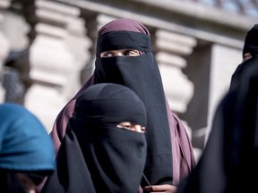 Burka-clad women protest the upcoming band of the controversial garment in Denmark.