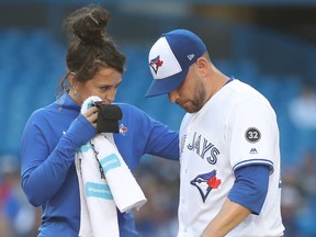 Marco Estrada of the Toronto Blue Jays is tended to by head athletic trainer Nikki Huffman before coming out of his team's game against the New York Mets in the first inning on July 3, 2018. (TOM SZCZERBOWSKI/Getty Images)