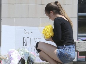 A steady stream of teens drop off flowers and hug in front of Malvern Collegiate Institute on Tuesday July 24, 2018. Reese Fallon, 18, who was killed in the mass shooting on the Danforth, was a recent graduate of the high school. (Veronica Henri/Toronto Sun/Postmedia Network)