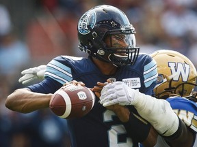 Toronto Argonauts quarterback James Franklin passes under pressure from Winnipeg Blue Bombers' Cory Johnson during the first half of CFL football action in Toronto, Saturday July 21, 2018.