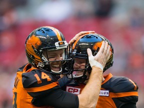 B.C. Lions’ quarterback Travis Lulay (left) shows his appreciation toward kicker Ty Long after he made a field goal. Long leads the league in gross average, with an impressive 50.9 yards per punt. Darryl Dyck/The Canadian Press