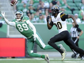 Roughriders’ Duron Carter (left) attempts a one-handed interception against Tiger-Cats’ Terrence Toliver.  Mark Taylor/THE CANADIAN PRESS/