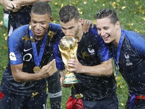 France's Kylian Mbappe, Lucas Hernandez, Florian Thauvin hold the trophy after the final match between France and Croatia at the 2018 soccer World Cup in the Luzhniki Stadium in Moscow, Russia, on July 15, 2018. (FRANK AUGSTEIN/AP)