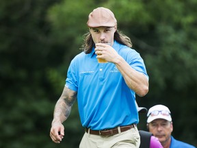 Ottawa Senators' Erik Karlsson takes a sip of his beer on the 12th hole during the pro-am ahead of the Canadian Open at the Glen Abbey Golf Club in Oakville, Ont., on Wednesday. THE CANADIAN PRESS/Nathan Denette
