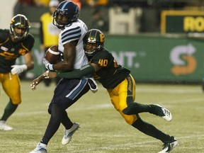 Edmonton Eskimos' Maurice McKnight (40) tackles Toronto Argonauts' S.J. Green (19) during the second half of a CFL football game at Commonwealth Stadium in Edmonton, on Friday, July 13, 2018.