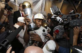 Kawhi Leonard holds up his MVP trophy after leading the Spurs to the NBA title in 2014, ending LeBron James’ Heat dynasty at the same time. (AP PHOTO)
