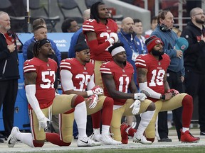 San Francisco 49ers outside linebacker Eli Harold, from bottom left, kneels with safety Eric Reid, wide receiver Marquise Goodwin and wide receiver Louis Murphy during the national anthem before an NFL game against the Jacksonville Jaguars in Santa Clara, Calif. on Dec. 24, 2017. (AP Photo/Marcio Jose Sanchez)