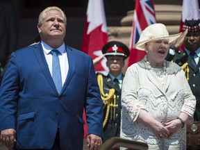 Premier Doug Ford and Lt.-Gov. Elizabeth Dowdeswell sing the national anthem during the public swearing-in ceremony at Queen's Park in Toronto on June 29, 2018. THE CANADIAN PRESS/Tijana Martin