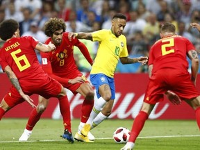 Brazil's Neymar, center attempts to get past the Belgian defence during the quarterfinal match between Brazil and Belgium at the 2018 soccer World Cup in the Kazan Arena, in Kazan, Russia, Friday, July 6, 2018.
