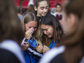 Members of the Markham Synchro club -- shooting victim Julianna Kozis, 10, was a member -- paying their respects during a vigil at Alexander the Great Parkette along the Danforth in Toronto, Ont. on Wednesday, July 25, 2018. (Ernest Doroszuk/Toronto Sun)