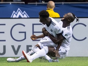 Vancouver Whitecaps' Alphonso Davies, left, and Kei Kamara celebrate Davies' second goal against Minnesota United during the second half of an MLS soccer game in Vancouver, on Saturday July 28, 2018.