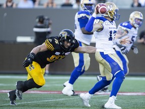 The Hamilton Tiger-Cats’ defence (featuring defensive end Julian Howsare, left) has turned opponents over just five times in four games, ranking dead-last in the league with Toronto. (The Canadian Press)