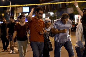 Civilians are escorted from the scene of a mass shooting in Toronto on Sunday, July 22, 2018. THE CANADIAN PRESS/Nathan Denette