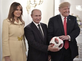 U.S. First Lady Melania Trump, left, Russian President Vladimir Putin, centre, and U.S. President Donald Trump, pose with a soccer ball after a press conference following their meeting at the Presidential Palace in Helsinki, Finland, Monday, July 16, 2018.