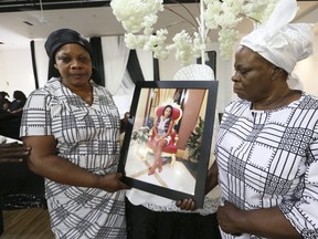Mary Yaboah, left, and Mary Amoah — the mother of murdered Toronto woman Jenas Nyarko — hold her picture at a memorial held in her honour at the Apostles Continuation Church International in Toronto on Sunday. (Jack Boland/Toronto Sun)