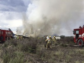 Rescue workers and firefighters are seen at the site where an Aeromexico airliner has suffered an "accident" in a field near the airport of Durango, Mexico, Tuesday, July 31, 2018. (Civil Defense Office of Durango Photo via AP)