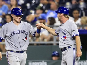 Danny Jansen #9 and  first base coach Tim Leiper #34 of the Toronto Blue Jays celebrate Jansen's hit against the Kansas City Royals in the eighth inning at Kauffman Stadium on August 13, 2018 in Kansas City, Missouri. (Photo by Brian Davidson/Getty Images)