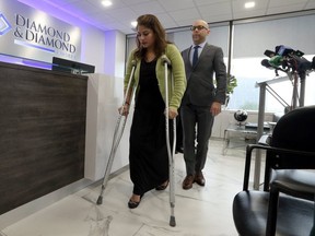 Darryl Singer, a lawyer with Diamond and Diamond, walks with Sonia Sheth, a victim of the bombing at Bombay Bhel.  (Dave Abel/Toronto Sun)