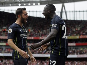 Manchester City's Bernardo Silva (left) celebrates with teammate Benjamin Mendy after scoring his side's second goal on Sunday against Arsenal. (AP PHOTO)