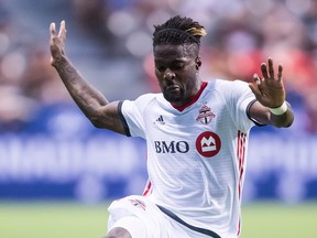 Toronto FC's Tosaint Ricketts falls on Vancouver Whitecaps' Doneil Henry during their game last week. (THE CANADIAN PRESS)