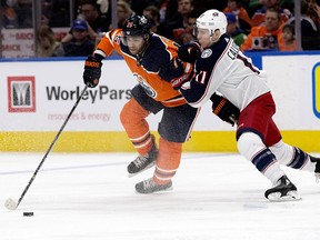 The Edmonton Oilers' Darnell Nurse (25) battles the Columbus Blue Jackets' Matt Calvert (11) during second period NHL action at Rogers Place, in Edmonton Tuesday March 27, 2018.