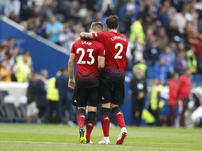 Manchester United's Luke Shaw and Victor Linelof leave the pitch after Sunday's loss to Brighton and Hove Albion. (AP PHOTO)