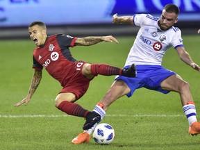 Toronto FC forward Sebastian Giovinco is fouled by Montreal Impact defender Rudy Camacho during Saturday's game. (THE CANADIAN PRESS)
