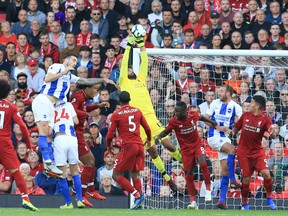 Liverpool goalkeeper Alisson Becker (C) claims the ball against Brighton and Hove Albion on Saturday. (GETTY IMAGES)