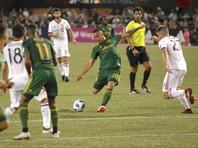 Portland Timbers' David Guzman shoots past Toronto FC's Liam Fraser during Wednesday night's game. (AP PHOTO)