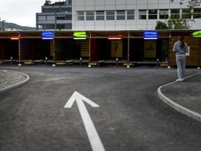 A prostitute faces the so-called "sex boxes" at the opening day of Switzerland's first sex drive-in on August 26, 2013 in Zurich, which is aiming to get prostitution off the city streets. The drive-in, which as darkness began to fall was bathed in colourful lights, has a track where the sex workers can show off their assets and negotiate a price, and nine so-called "sex boxes" where they and their clients can park and conclude the transaction.