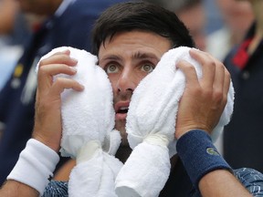 Novak Djokovic puts an ice towel to his face during a changeover in his match against Marton Fucsovics during the first round of the U.S. Open, Tuesday, Aug. 28, 2018, in New York.
