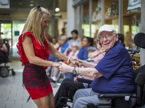 Baycrest therapeutic recreation staff member and prom coordinator Cindy Kaiser helps resident Mendel Good enjoy his time at the Baycrest Centennial Prom on Tuesday. (Ernest Doroszuk/Toronto Sun)