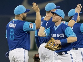 Toronto Blue Jays' Kendrys Morales and Billy McKinney high five after defeating the Philadelphia Phillies in their Interleague MLB baseball game in Toronto on Friday August 24, 2018.