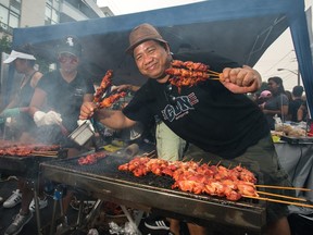 Edwin Laurilla shows off some Filipino barbecue during Taste of Manila in Toronto, Ont. on Saturday, Aug. 18 2018.