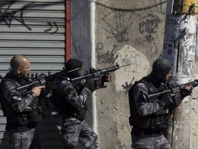 Elite police patrol one day after police came under fire during a shift change in the Alemao slum complex in Rio de Janeiro, Brazil, Monday, July 16, 2018. Rio is experiencing a wave of violence as gangs vie for control and police struggle to maintain order. (AP Photo/Leo Correa)