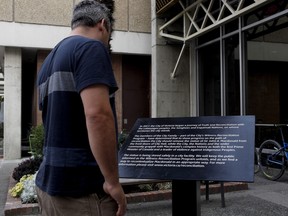 A second plaque has been installed to replace a bronze statue of Canada's first Prime Minister Sir John A. Macdonald after it was vandalized shortly after the removal of the statue over the weekend. People walk by the plaque daily as it stands in front of City Hall Victoria, B.C., on Tuesday, August 14, 2018. THE CANADIAN PRESS/Chad Hipolito