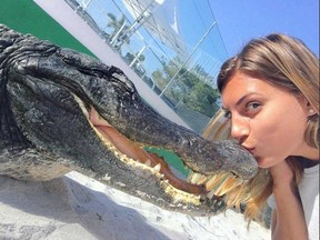 Gabby Scampone kisses a gator. (INSTAGRAM)