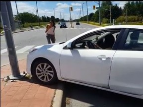 A white sedan hits a pole in an altercation in Brampton captured on video on Friday, Aug. 10, 2018. (Facebook)