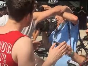 A protester attacks Toronto Sun photographer Stan Behal at a rally Saturday, Aug. 11, 2018 at Nathan Phillips Square.