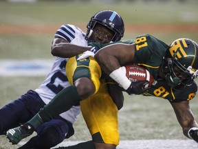 Argonauts’ Cassius Vaughn (left) tackles Edmonton Eskimos D’haquille Williams during a game in Edmonton last month. Vaughn sustained an Achilles injury last Friday and will be sidelined for the remainder of the season. (CP FILE)