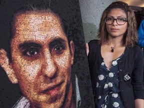 Ensaf Haidar stands next to a poster of a book of articles written by the imprisoned Saudi blogger and Haidar's husband, Raif Badawi, on June 16, 2015 in Montreal.